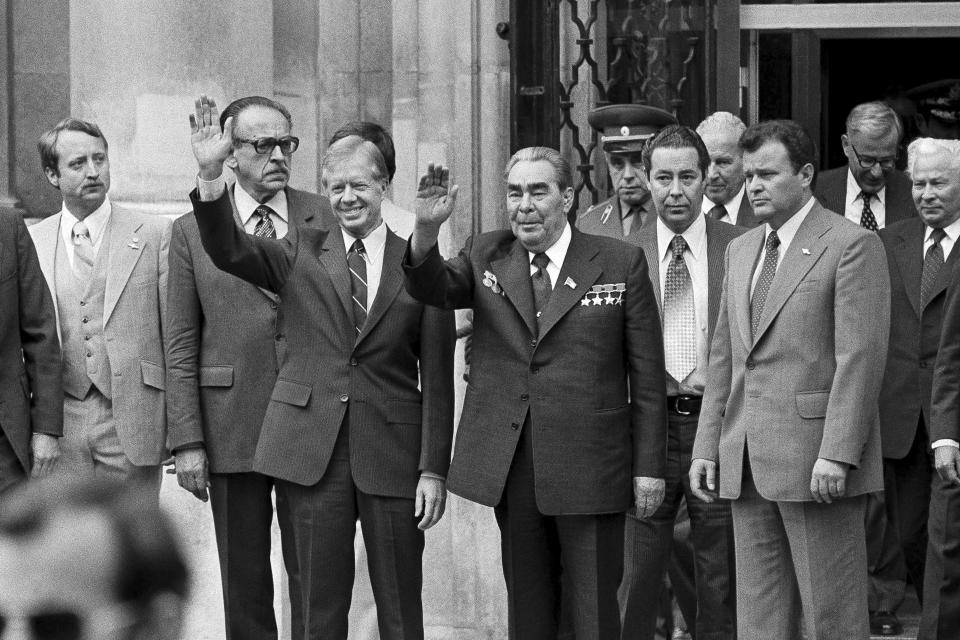 FILE - President Jimmy Carter, center left, and Soviet President Leonid Brezhnev, center right, wave to the waiting crowd outside the U.S. Embassy after both heads of state finished their first round of talks prior to the Monday Salt II Treaty signing, June 16, 1979, in Vienna, Austria. In the Brezhnev years, Washington and Moscow engaged in the so-called "detente" period that saw several arms treaties signed, improved trade relations and the Apollo-Soyuz spacecraft docking, the first joint mission in outer space. (AP Photo/File)