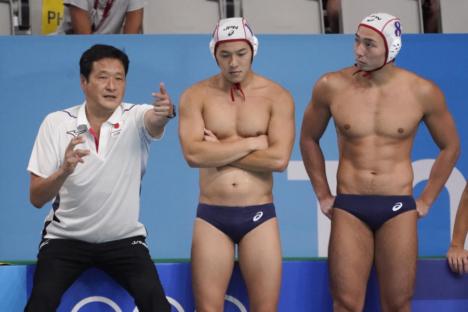 Japan's head coach Yoji Omoto talks with his players during a preliminary round men's water polo match against Hungary at the 2020 Summer Olympics, Tuesday, July 27, 2021, in Tokyo, Japan. (AP Photo/Mark Humphrey)