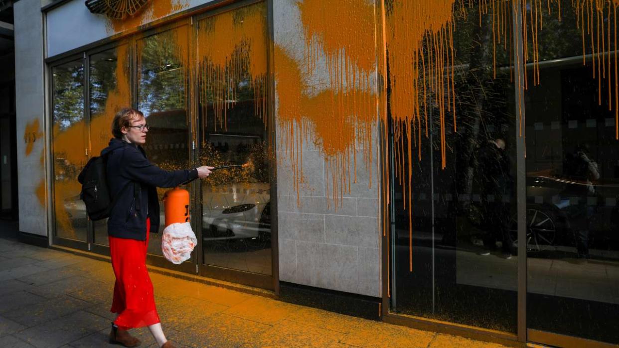 Un membre du groupe Just Stop Oil a pulvérisé de la peinture orange sur la vitrine d’une concession Aston Martin, à Londres, ce dimanche 16 octobre.