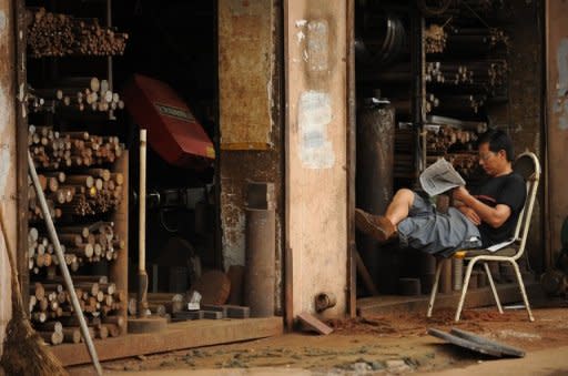 A machinist sits outside his workshop in Shanghai. Weak economic data in the current third quarter have raised fears China's growth may have slowed for a seventh straight quarter when GDP figures are released next month