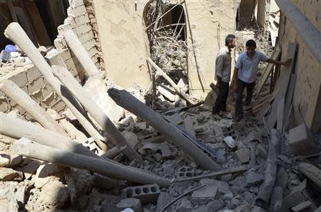 Men inspect a site hit by what activists said was shelling by forces loyal to Syria's President Bashar al-Assad, in the Duma neighbourhood of Damascus September 4, 2013. REUTERS/Bassam Khabieh