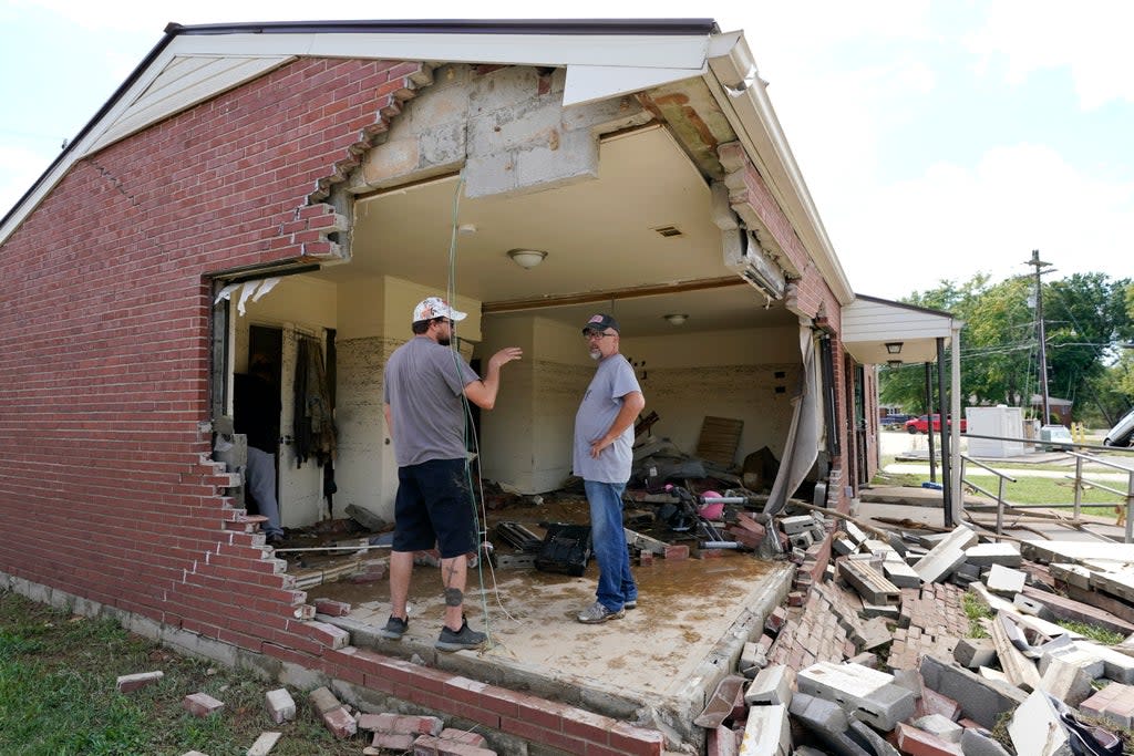 Brian Mitchell, right, looks through the damaged home of his mother-in-law along with family friend Chris Hoover in Waverly on Sunday (Mark Humphrey/AP)