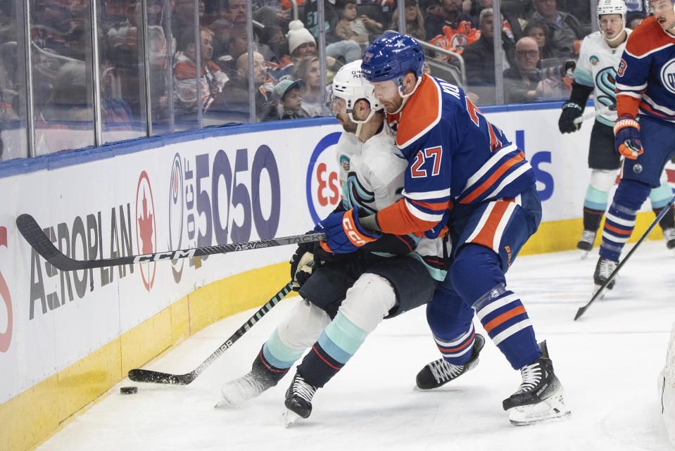 Seattle Kraken's Oliver Bjorkstrand (22) and Edmonton Oilers' Brett Kulak (27) battle for the puck during the first period of an NHL hockey game, Wednesday, Nov. 15, 2023 in Edmonton, Alberta. (Jason Franson/The Canadian Press via AP)