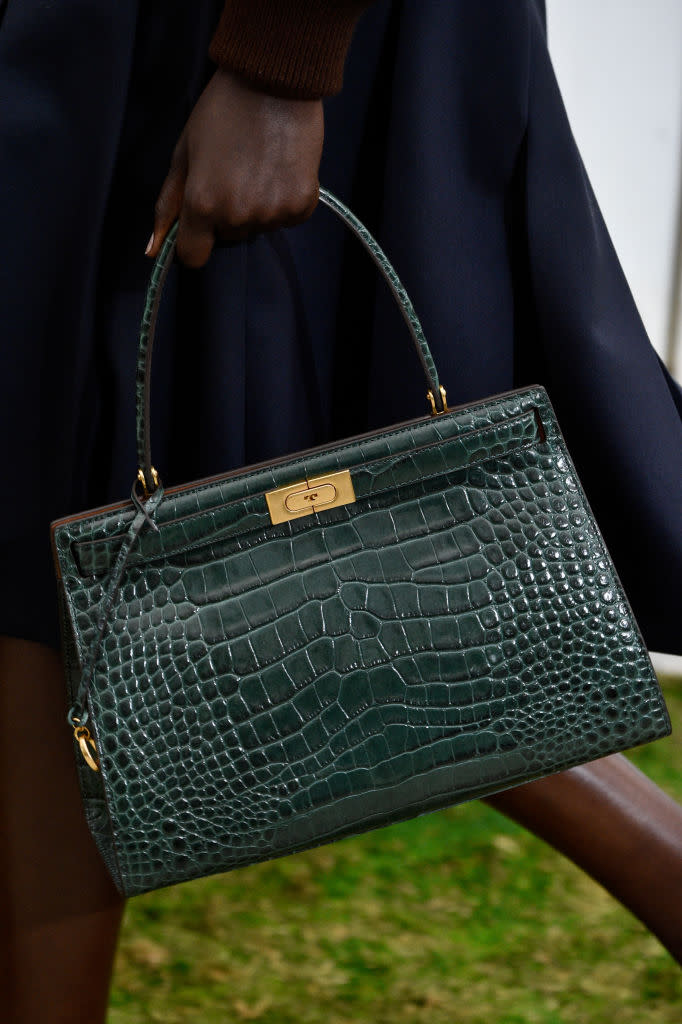 <p>A model carries a green, crocodile-texture bag from the Tory Burch FW18 show. (Photo: Getty Images) </p>