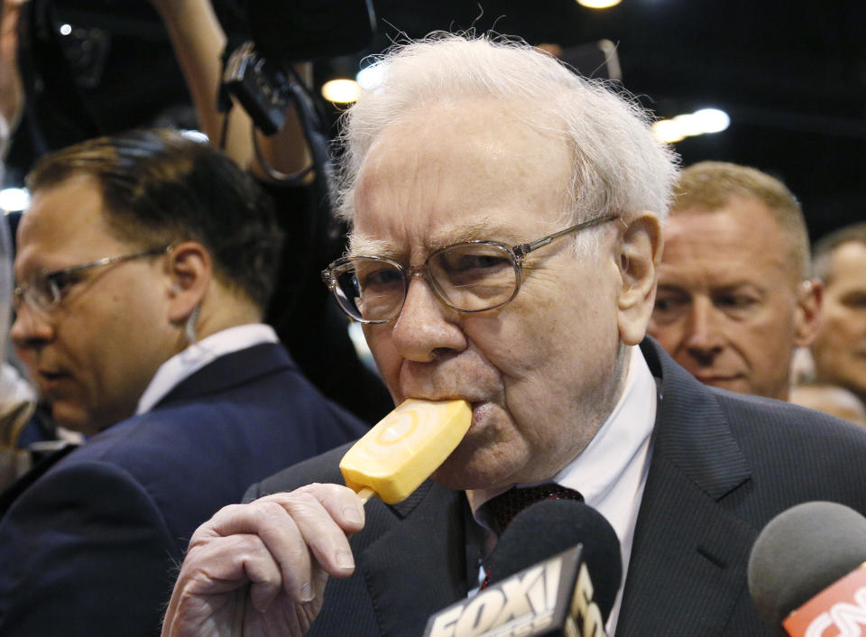 Berkshire Hathaway CEO Warren Buffett bites into an ice cream during a trade show at the company's annual meeting in Omaha, Nebraska May 3, 2014. Warren Buffett's Berkshire Hathaway Inc on Friday said quarterly profit declined 4 percent, falling short of analyst forecasts, as earnings from insurance underwriting declined and bad weather disrupted shipping at its BNSF Railway unit. REUTERS/Rick Wilking   (UNITED STATES - Tags: BUSINESS TPX IMAGES OF THE DAY)