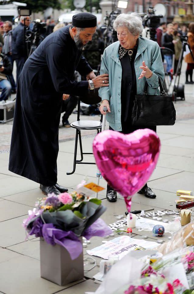 Mr Patel helps Ms Black away from the floral memorial. Source: Reuters