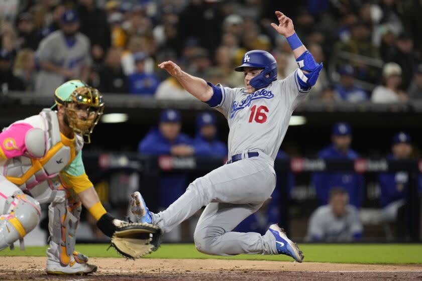 Los Angeles Dodgers' Will Smith slides into home, scoring from first off a double by Jason Heyward and a fielding error by San Diego Padres right fielder Fernando Tatis Jr. as San Diego Padres catcher Austin Nola waits for the throw during the seventh inning of a baseball game Friday, May 5, 2023, in San Diego. (AP Photo/Gregory Bull)