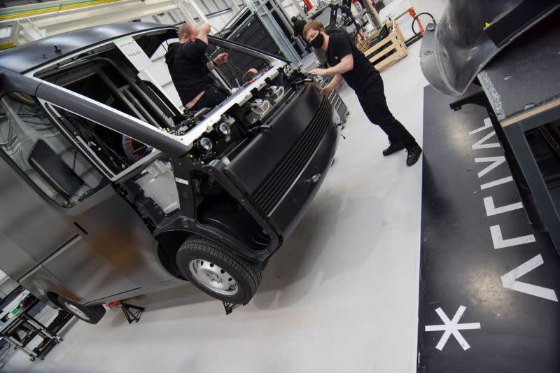 Workers build a fully-electric test van at electric van and bus maker Arrival Ltd, in Banbury