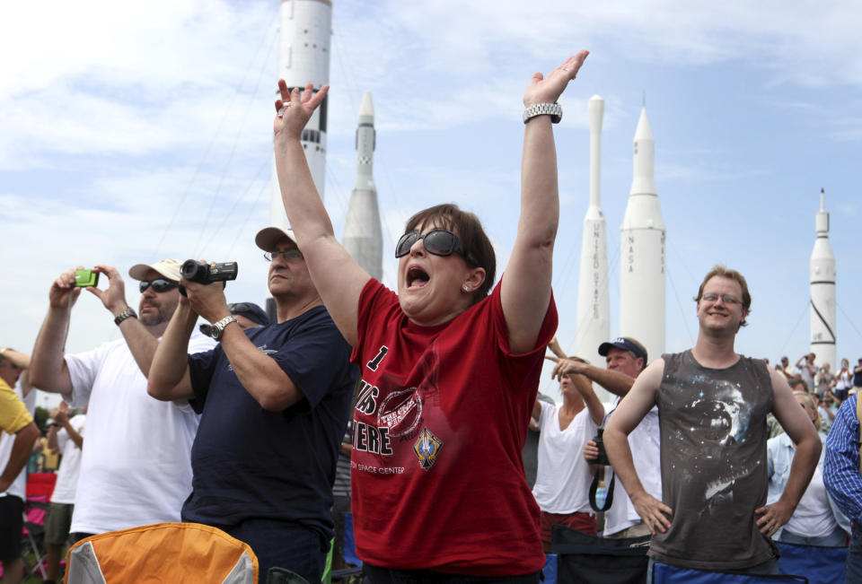 FILE - In this July, 8, 2011 file photo, Vanessa Fabrega, of Austin, Texas, cheers as she and others watch the launch of space shuttle Atlantis from the Kennedy Space Center Visitor Complex in Cape Canaveral, Fla. Atlantis was the 135th and final shuttle launch for the U.S. (AP Photo/Julie Fletcher)