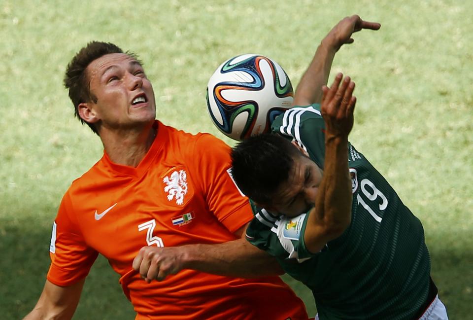 Stefan de Vrij of the Netherlands fights for the ball with Mexico's Oribe Peralta during their 2014 World Cup round of 16 game at the Castelao arena