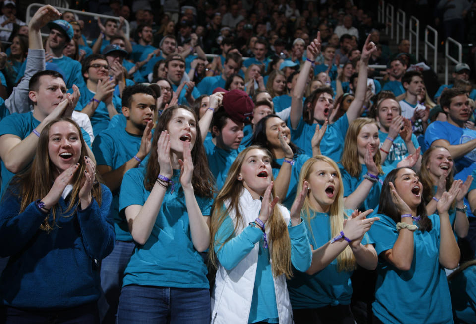 Michigan State students wearing teal-colored T-shirts in the “Izzone,” a vocal student cheering section named after head basketball coach Tom Izzo, cheer during an NCAA college basketball game against Wisconsin, Friday, Jan. 26, 2018, in East Lansing, Mich. (AP Photo/Al Goldis)