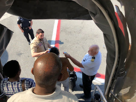 FILE PHOTO: Passengers leave the plane being assisted by the air cabin crew and the emergency services on a flight from New York to Dubai, on JFK Airport, New York, U.S., September 05, 2018 in this still image obtained from social media. Larry Coben/via REUTERS