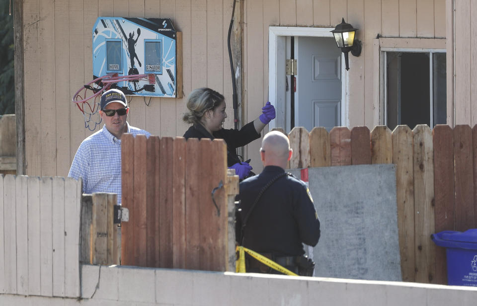 San Diego Police investigate the home where two adults and three children died from gunshot wounds during a domestic shooting in the Paradise Hills area in San Diego, Calif., Saturday, Nov. 16, 2019. A husband and wife and three of their young children died Saturday morning at the family's San Diego home in what police believe was a murder-suicide sparked by a bitter divorce. One son is in critical condition. (Hayne Palmour IV/The San Diego Union-Tribune via AP)