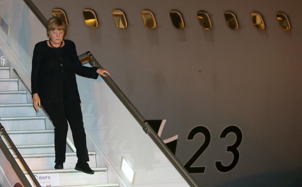German Chancellor Merkel disembarks from an aircraft upon her arrival in New Delhi