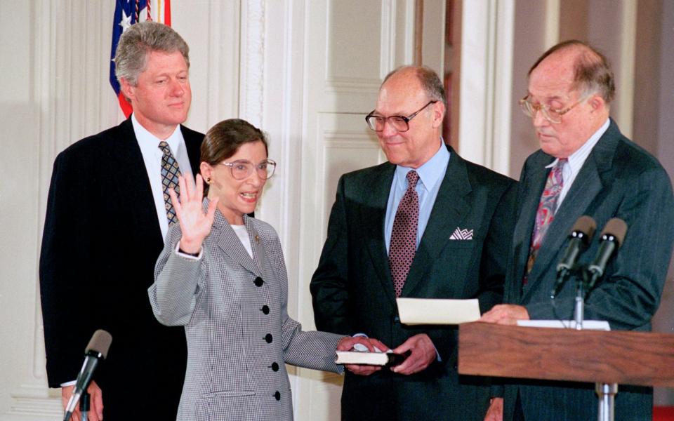 Ginsburg taking the oath of the court in 1993 beside President Clinton, her husband Martin, and Chief Justice William Rehnquist  - AP