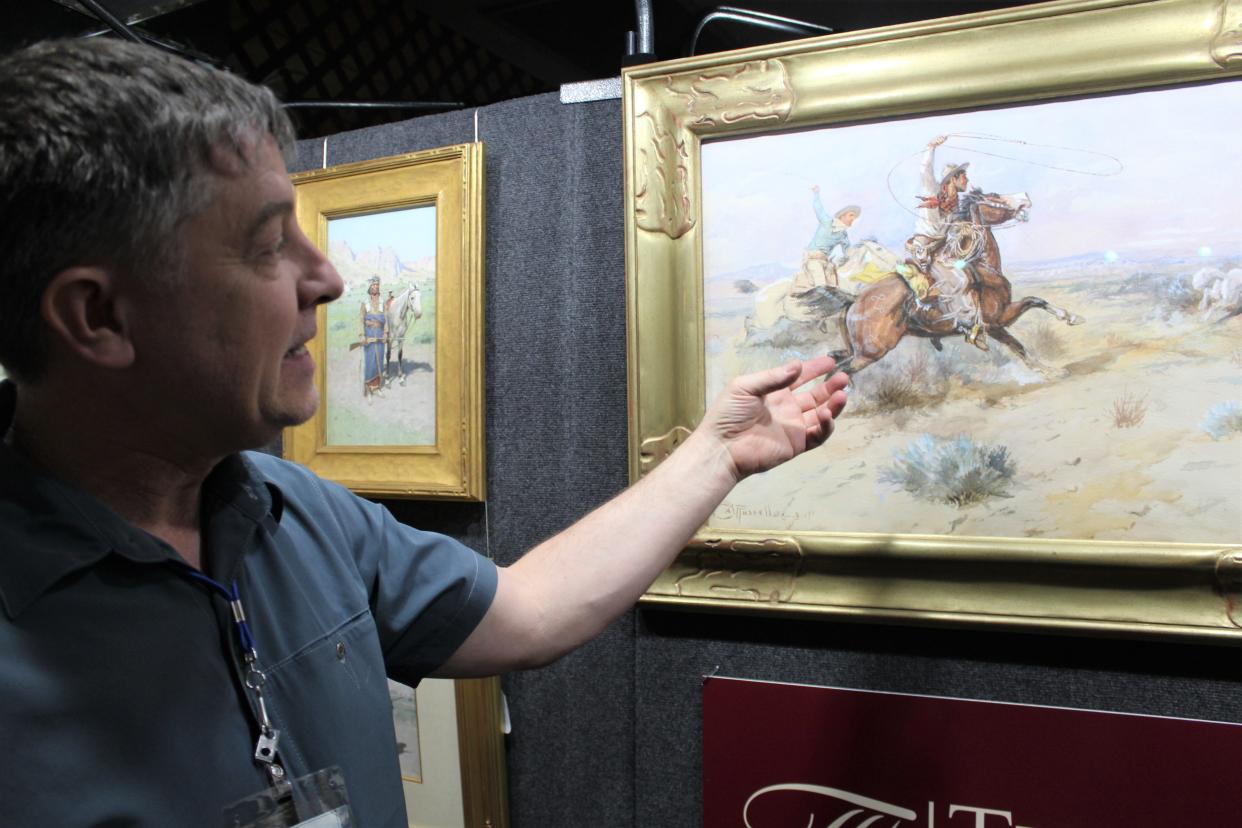 Bozeman art dealer Curtis Tierney describes the detail within the Charlie Russell watercolor "Roping a White Wolf." The painting is currently for sale at the March in Montana dealers show and is expected to bring in excess of $1 million.