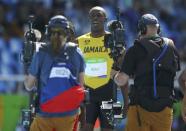 2016 Rio Olympics - Athletics - Preliminary - Men's 100m Round 1 - Olympic Stadium - Rio de Janeiro, Brazil - 13/08/2016. Usain Bolt (JAM) of Jamaica is followed by camera crew after his race. REUTERS/Ivan Alvarado