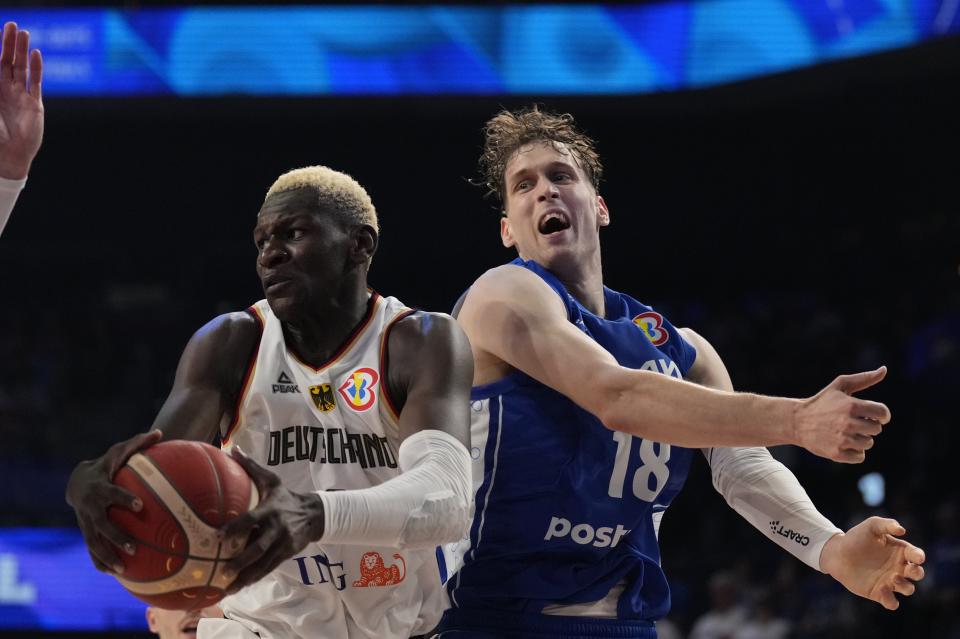 Germany guard Isaac Bonga (0), left, tries to keep a rebound against Finland forward Mikael Jantunen (18) in the first half of their Basketball World Cup group E match in Okinawa, southern Japan, Tuesday, Aug. 29, 2023. (AP Photo/Hiro Komae)