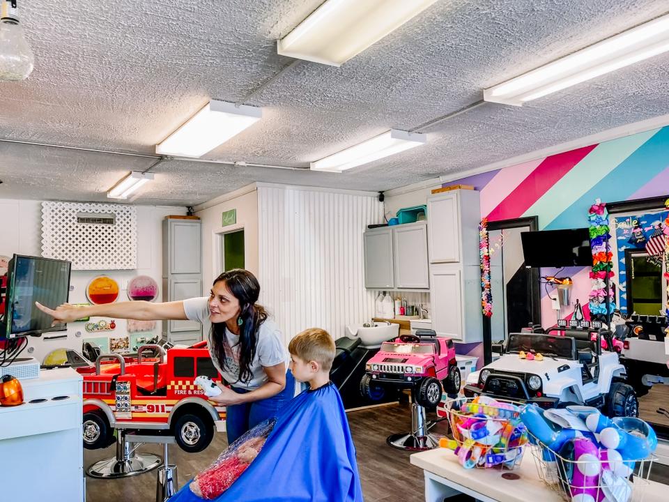 Six-year-old Peter O'Donnell plays Minecraft while Samantha Weatherford prepares to cut his hair at Brave Little Clippers in Fountain City on Aug. 3, 2022.