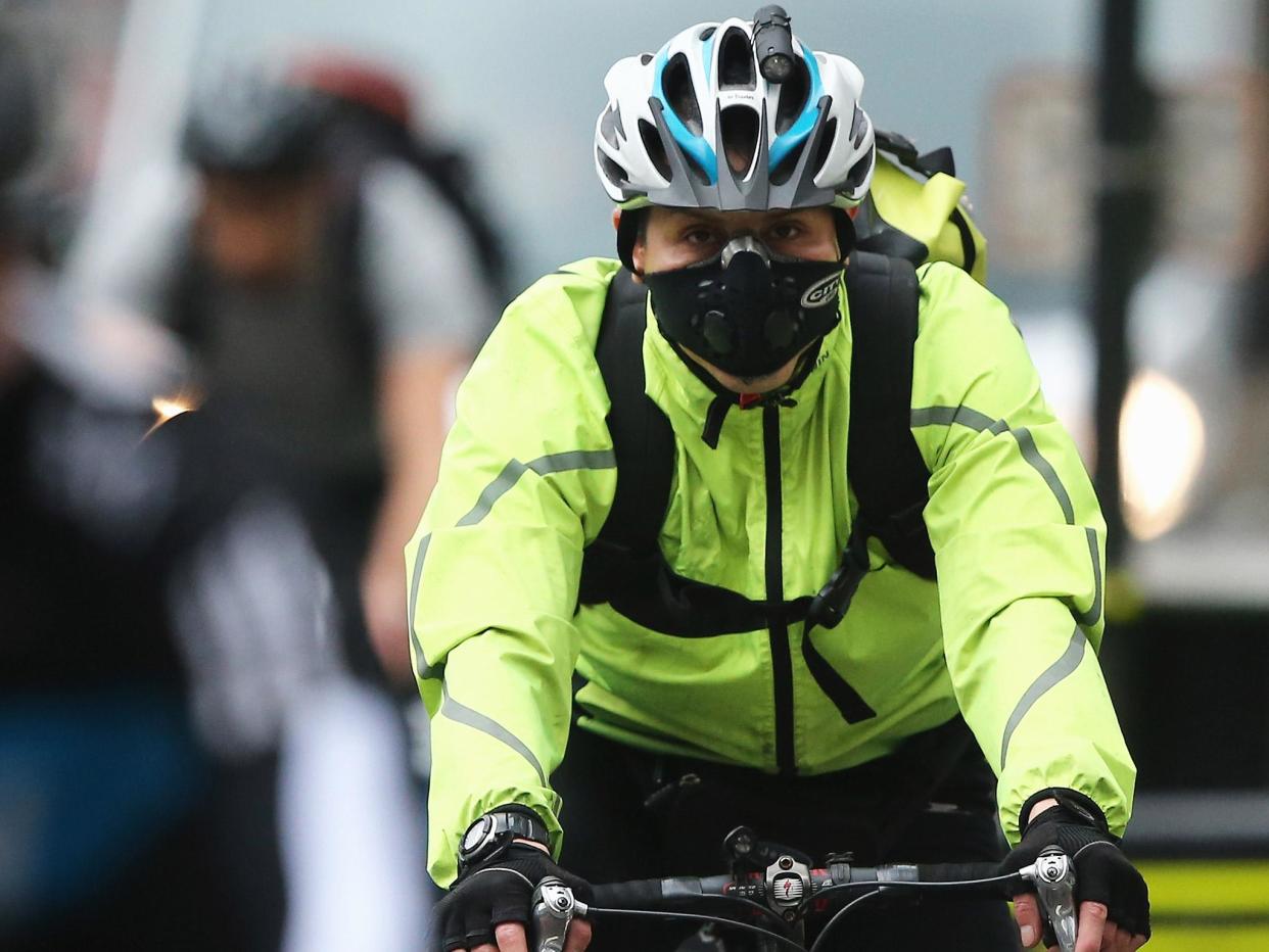 A London cyclist wears a face mask to avoid inhaling pollution: Getty