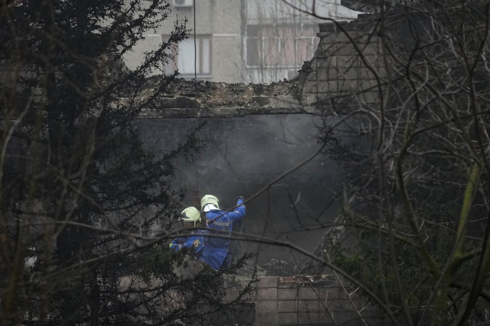 Rescuers work at the scene where a helicopter crashed on civil infrastructure in Brovary, in the outskirts of Kyiv, Ukraine, Wednesday, Jan. 18, 2023. The chief of Ukraine's National Police says a helicopter crash in a Kyiv suburb has killed 16 people, including Ukraine's interior minister and two children. He said nine of those killed were aboard the emergency services helicopter. (AP Photo/Efrem Lukatsky)