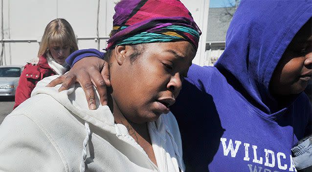 Distressed neighbour Tori Childs is led away after the discovery of the bodies Photo: AP