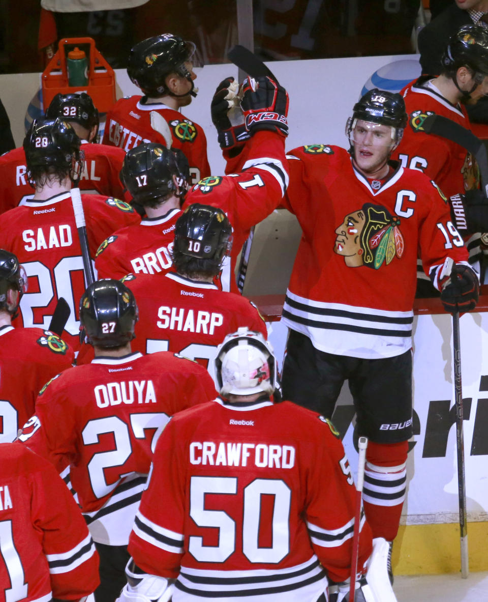 Chicago Blackhawks center and Captain Jonathan Toews, right, celebrates with his teammates after the Blackhawks' 2-0 win over the St. Louis Blues after Game 3 of a first-round NHL hockey Stanley Cup playoff series game Monday, April 21, 2014, in Chicago. (AP Photo/Charles Rex Arbogast)