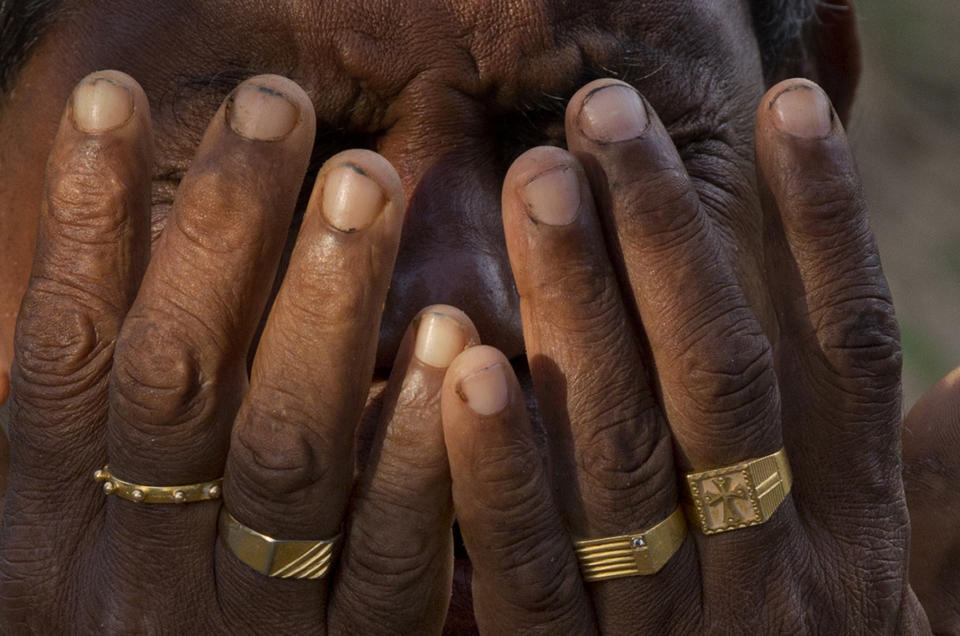 In this April 23, 2019, file photo, Melton Roy, prays amid the newly buried graves of Easter Sunday bomb blast victims at Methodist burial ground in Negombo, Sri Lanka. (AP Photo/Gemunu Amarasinghe, File)