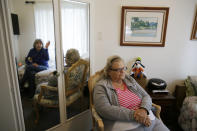 In this photo taken Thursday, Dec. 5, 2019, Rosalie Harris, 80, right, sits in her room and talks with her sister, Marcey Smith, left in mirror, who was visiting at the Cedars Care Home in Calistoga, Calif. Even before widespread blackouts hit California this fall, the utility that triggered them showed signs it wasn’t fully prepared. An Associated Press review reveals persistent problems during four smaller shutoffs that Pacific Gas & Electric did starting last year so power lines downed by strong winds wouldn’t spark wildfires. (AP Photo/Eric Risberg)