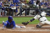 Chicago Cubs' Nelson Velazquez slides safely past Milwaukee Brewers catcher Victor Caratini during the sixth inning of a baseball game Tuesday, July 5, 2022, in Milwaukee. Velazquez scored on a hit by Rafael Ortega. (AP Photo/Morry Gash)