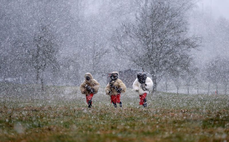 Revellers dressed as devils walk through the village of Valasska Polanka