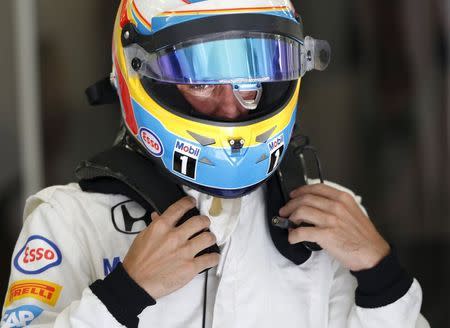 McLaren Formula One driver Fernando Alonso of Spain wears his helmet at the pit-lane during the first free practice ahead of Bahrain's F1 Grand Prix at Bahrain International Circuit, south of Manama April 17, 2015. REUTERS/Ahmed Jadallah