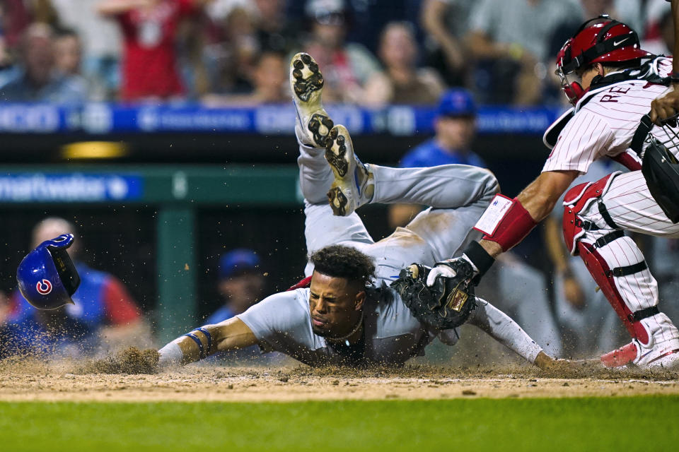 Chicago Cubs' Christopher Morel scores scores past Philadelphia Phillies' J.T. Realmuto during the 10th inning of a baseball game Saturday, July 23, 2022, in Philadelphia. (AP Photo/Matt Rourke)