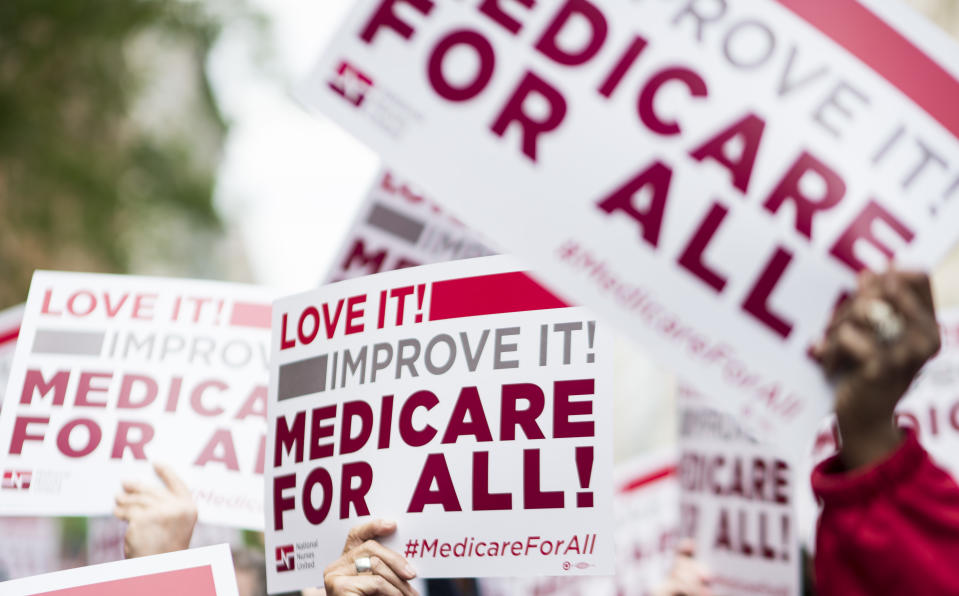 UNITED STATES - APRIL 29: Members of National Nurses United union members wave "Medicare for All" signs during  a rally in front of the Pharmaceutical Research and Manufacturers of America in Washington calling for "Medicare for All" on Monday, April 29, 2019.  (Photo By Bill Clark/CQ Roll Call)