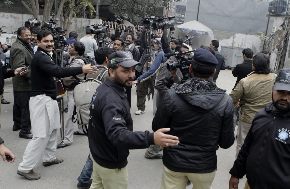 Pakistani police officers remove members of the media from a police station where cricket star, Umar Akmal, is detained, in Lahore, Pakistan, Saturday, Feb. 1, 2014. Police have detained Pakistan cricketer Umar Akmal and charged him with slapping a traffic sergeant after violating a traffic signal in Lahore. (AP Photo/K.M. Chaudary)