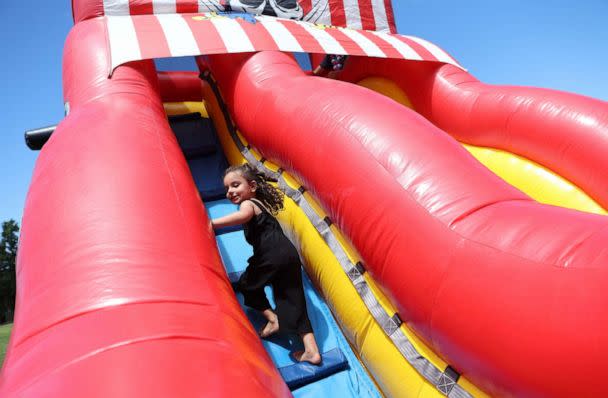 PHOTO: Zahra Mohammadi, 3, climbs an inflatable slide at a Fourth of July celebration in Sacramento, Calif., July 4, 2022. (Brittany Hosea-Small/Reuters)