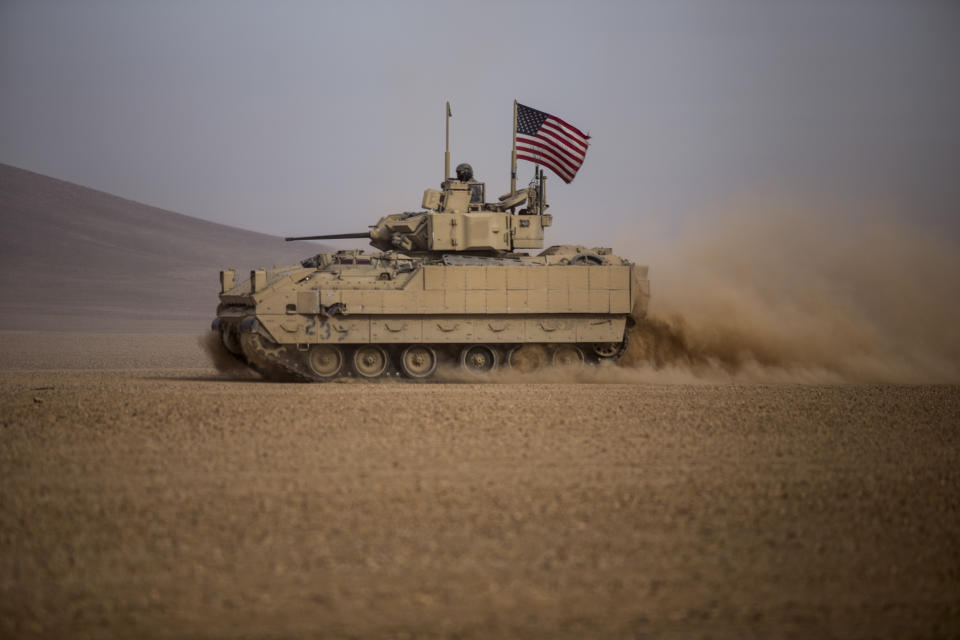 FILE - American soldiers drive a Bradley fighting vehicle during a joint exercise with Syrian Democratic Forces at the countryside of Deir Ezzor in northeastern Syria, Dec. 8, 2021. The U.S. is finalizing a massive package of military aid for Ukraine that U.S. officials say is likely to total as much as $2.6 billion. It's expected to include for the first time nearly 100 Stryker combat vehicles and at least 50 Bradley fighting vehicles to allow Ukrainian forces to move more quickly and security on the front lines. (AP Photo/Baderkhan Ahmad, File)