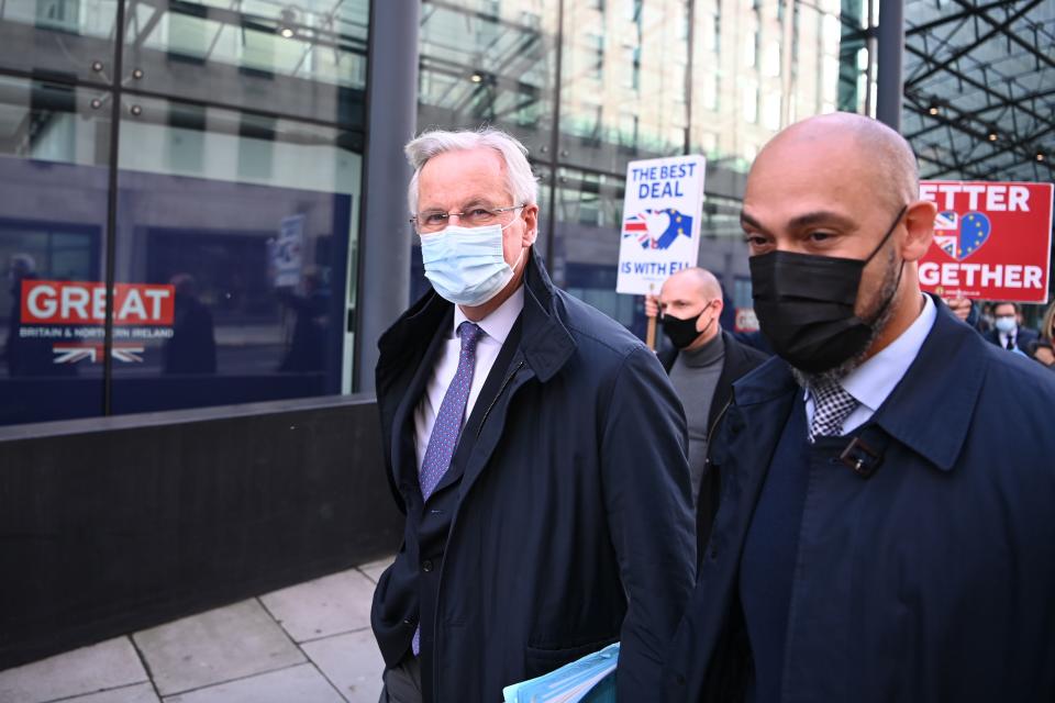 EU chief negotiator Michel Barnier (L) wearing a face mask because of the novel coronavirus pandemic, is followed down a street by Anti-Brexit activists as talks continue between the EU and the UK in London on November 13, 2020. - The European Union and Britain said major divergences remain but that post-Brexit negotiations would continue this week to clinch a trade deal in the scant time left. (Photo by DANIEL LEAL-OLIVAS / AFP) (Photo by DANIEL LEAL-OLIVAS/AFP via Getty Images)