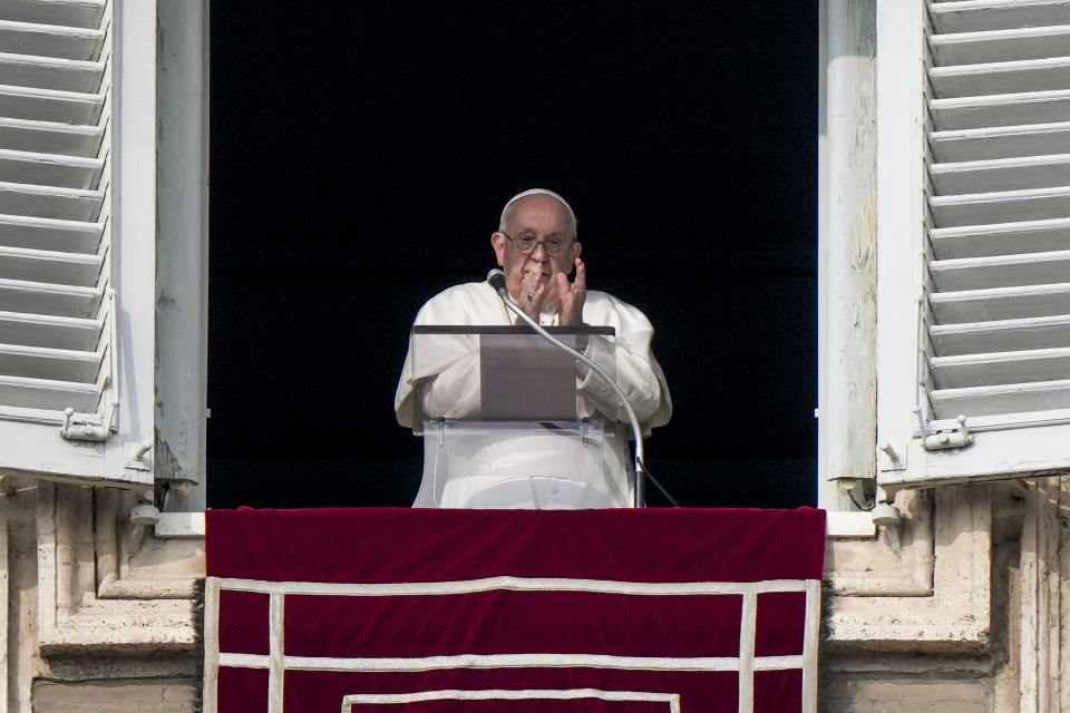 Pope Francis applauds while he remembers late Pope Emeritus Benedict XVI who died a year ago on Dec. 31, 2022, as he recites the Angelus noon prayer from the window of his studio overlooking St. Peter's Square, at the Vatican, Sunday, Dec. 31, 2023. (AP Photo/Andrew Medichini)