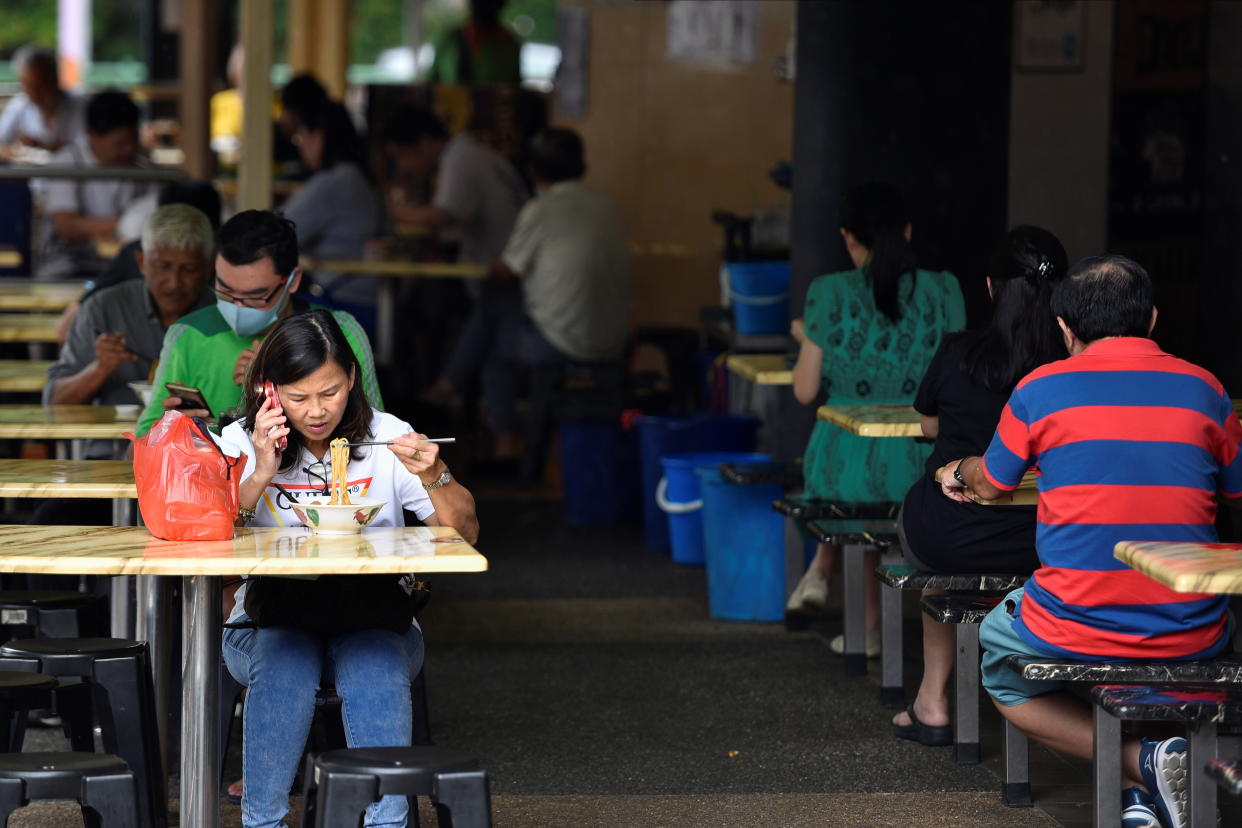 People eat outdoors before restrictions on outdoor dining kicks in on Sunday, due to the surge in coronavirus disease (COVID-19) cases in Singapore May 14, 2021. REUTERS/Caroline Chia