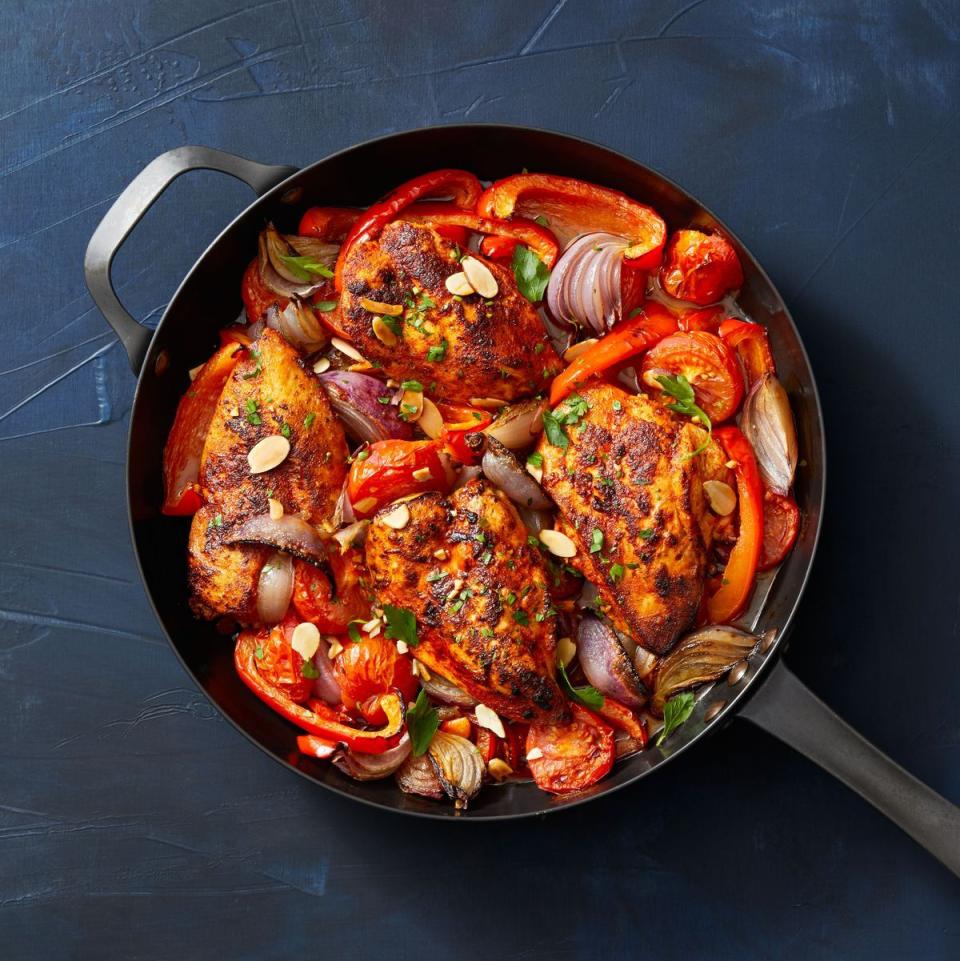 chicken with stewed peppers and tomatoes on a skillet