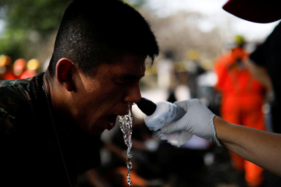 <p>A man has his face washed by a rescue worker near an area affected by the eruption of the Fuego volcano at El Rodeo in Escuintla, Guatemala June 6, 2018. REUTERS/Jose Cabezas – RC170767D540 </p>