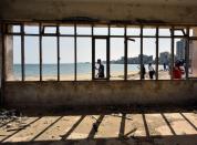 People walk on a beach in the abandoned coastal area of Varosha