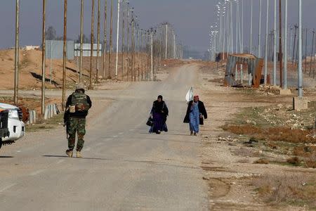 Displaced people from Mosul, who are fleeing from Islamic State militants, carry white flag next to Iraqi army In the northern site of Mosul, Iraq, December 29, 2016. REUTERS/Khalid al Mousily