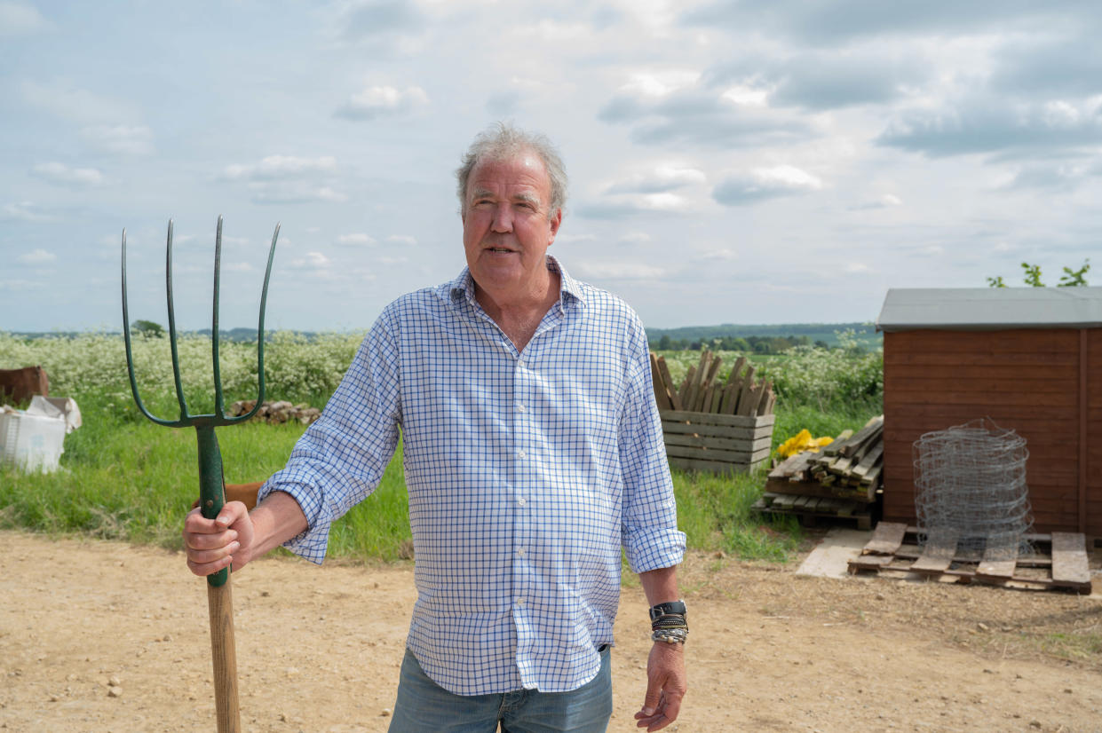 Jeremy Clarkson holds pitch fork on farm