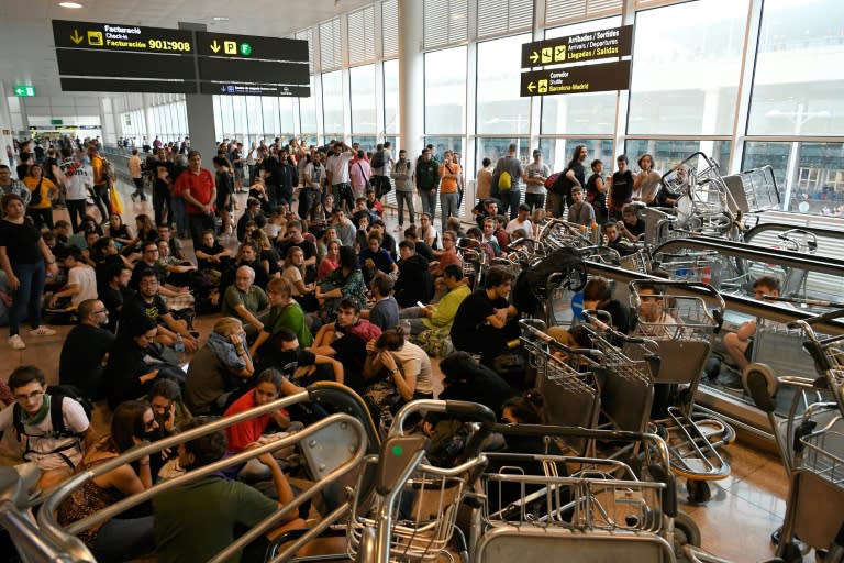 Unos manifestantes bloquean unas escaleras en el aeropuerto barcelonés de El Prat el 14 de octubre de 2019 para protestar por la sentencia del Tribunal Supremo español contra doce líderes independentistas catalanes