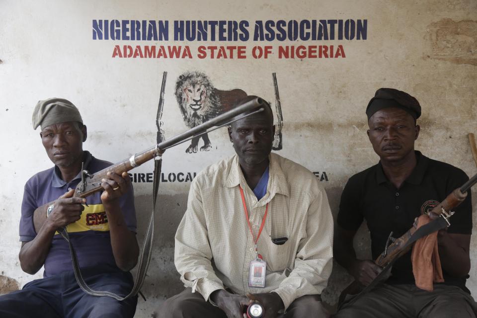 Local hunters pose with dane guns near a polling station following the presidential election being delayed by the Independent National Electoral Commission in Yola, Nigeria, Saturday, Feb. 16, 2019. A civic group monitoring Nigeria's now-delayed election says the last-minute decision to postpone the vote a week until Feb. 23 "has created needless tension and confusion in the country." (AP Photo/Sunday Alamba)