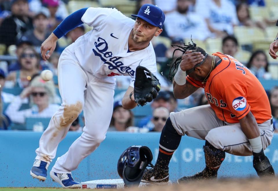 Houston Astros left fielder Corey Julks slides safely into third behind Michael Busch.