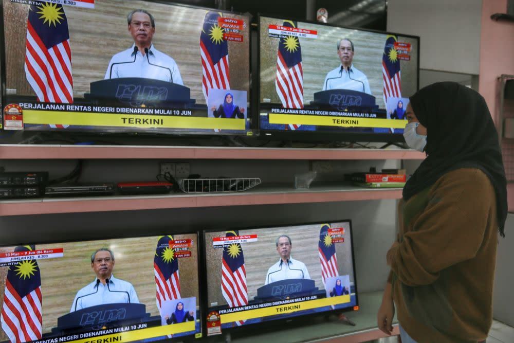 A woman watches a live broadcast of Prime Minister Tan Sri Muhyiddin Yassin on the recovery movement control order in Kuala Lumpur June 7, 2020. ― Picture by Ahmad Zamzahuri