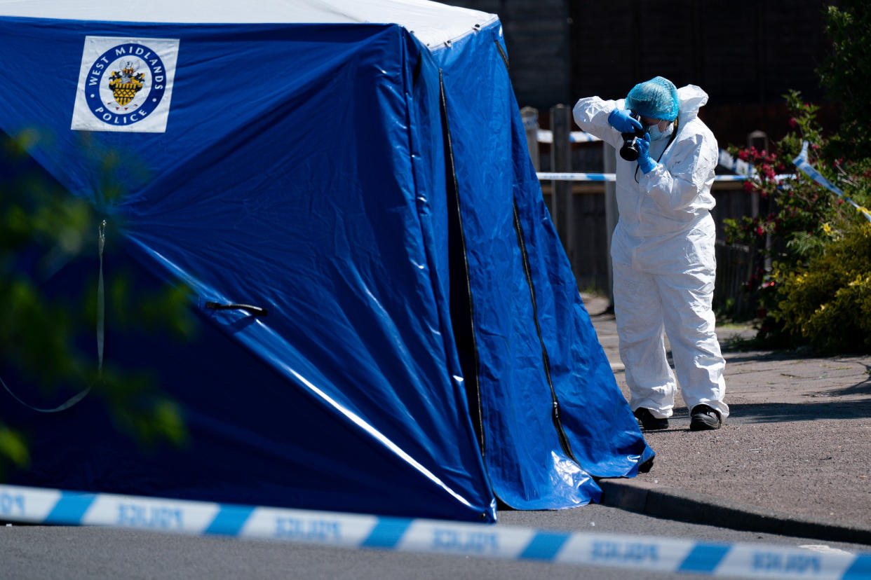 A forensics officer takes photographs at the scene on College Road, Kingstanding, north of Birmingham, where a 14-year-old boy died after being stabbed on Monday evening. Police have launched a murder investigation and are hunting up to seven people in connection with the attack. Picture date: Tuesday June 1, 2021.